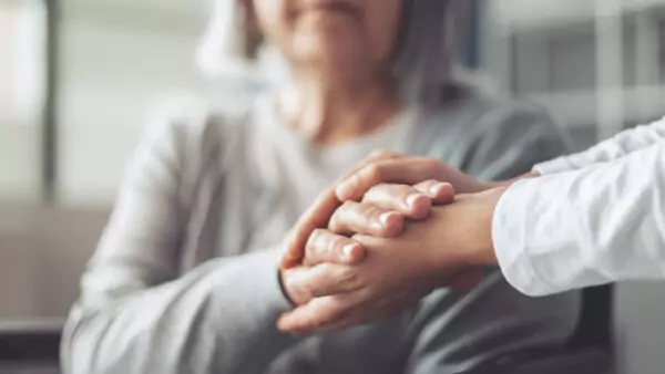 Focus sur les mains d'une personne aidante et d'une dama âgée.