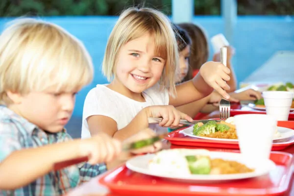 De jeunes enfants mangent à la cantine