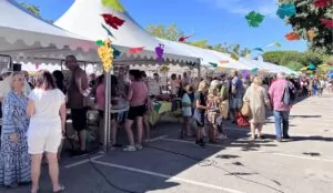 Des visiteurs découvrent les stands d’associations lors d’un forum installé sous des chapiteaux décorés.
