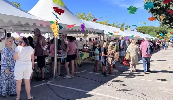 Des visiteurs découvrent les stands d’associations lors d’un forum installé sous des chapiteaux décorés.