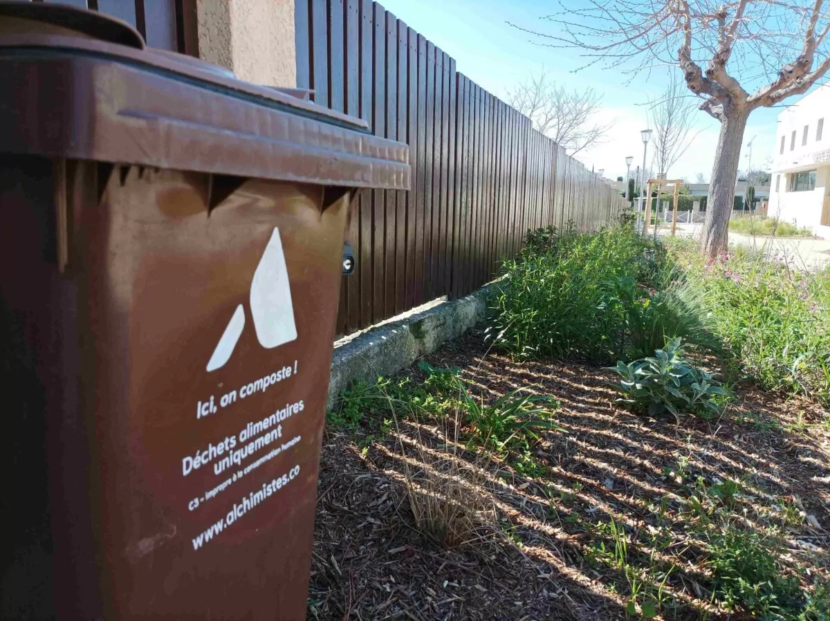 poubelle marron de compost devant une école maternelle