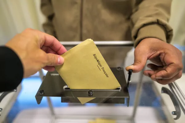 Focus sur une urne transparente et le vote d'un électeur