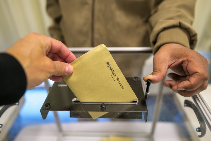 Focus sur une urne transparente et le vote d'un électeur